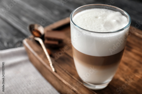 Bild auf Leinwand Glass of tasty aromatic latte on wooden board