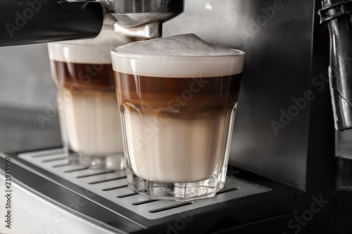 Coffee machine making latte, closeup