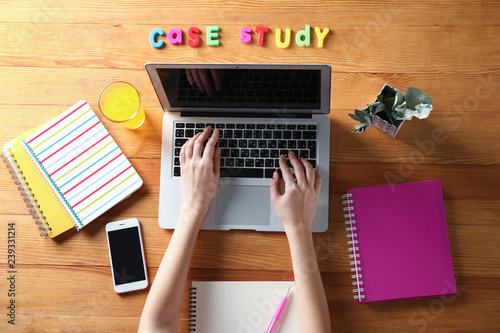 Woman using laptop on wooden table. Concept of study