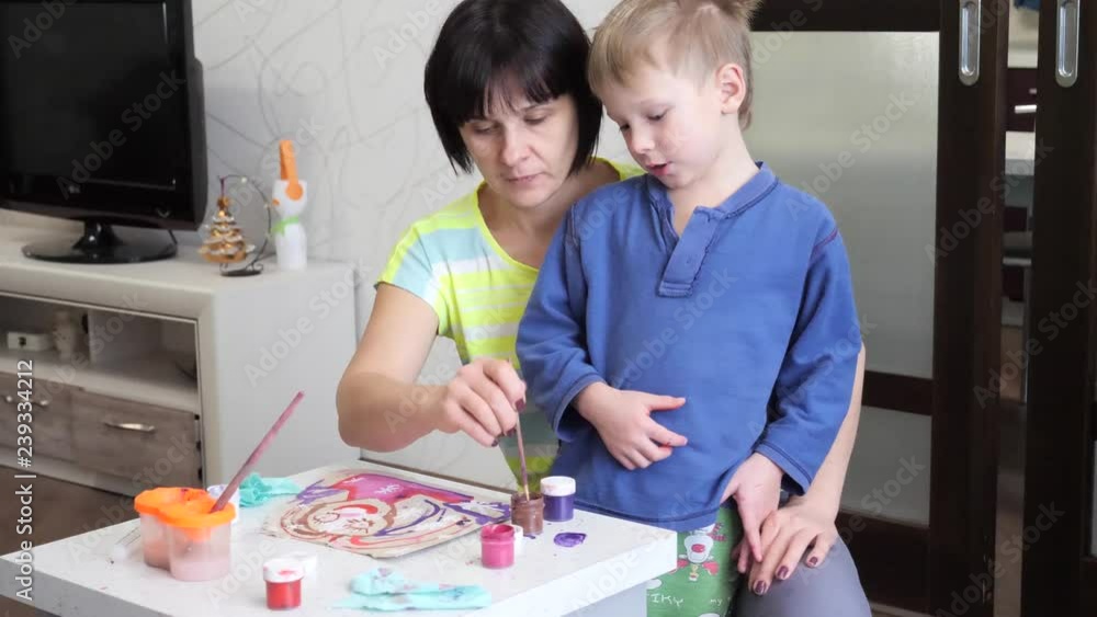 child boy enthusiastically paints with watercolors on paper. child boy enthusiastically paints with watercolors on paper.