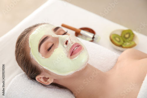 Young woman with natural facial mask in beauty salon