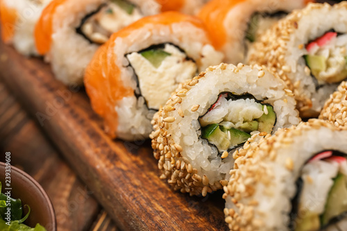 Tasty sushi rolls on board, closeup