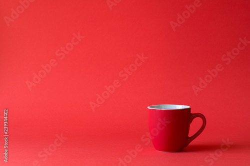 Red cups of tea or coffee on red paper background. Copy space