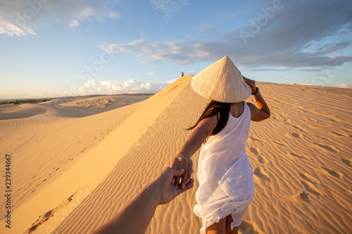 Foto back view of Asian Woman travel with hat looking at White Sand dunes Mui ne, in