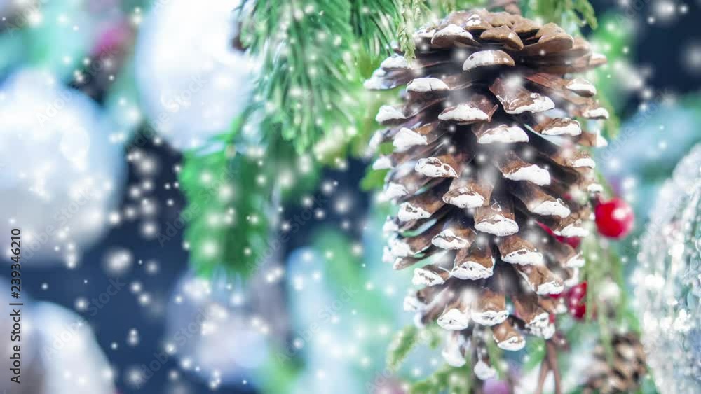Natural Christmas New Year's toy pine cone and Christmas tree branch close-up. Snowfall, falling snowflakes, spots white color. Winter Christmas New Year background. Cinemagraph seamless loop