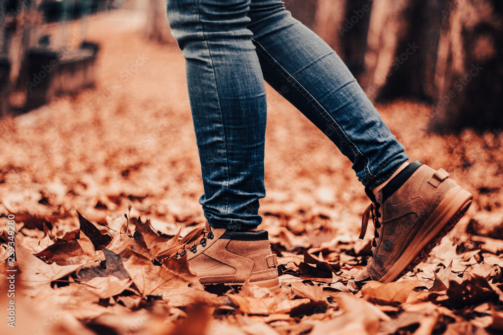 Boots on a path of fallen leaves in autumn, brown landscape Boots on a path of fallen leaves in autumn, brown landscape