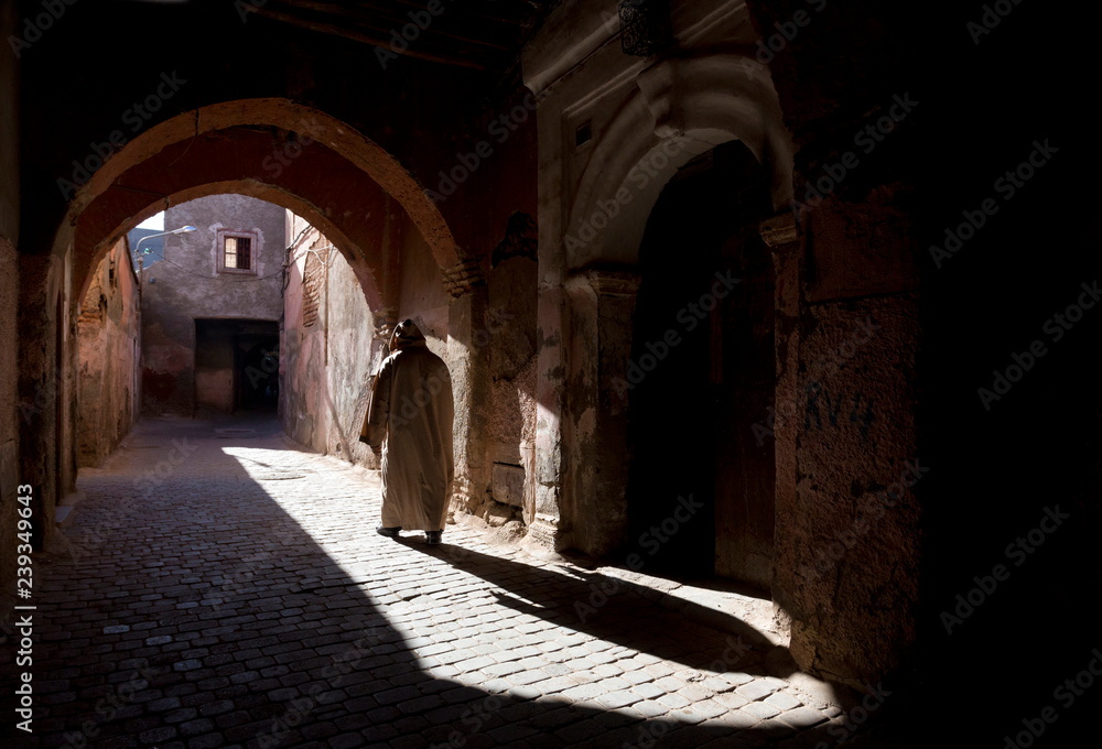 Local man wearing a djellaba casting a long shadow in a sunlit street in the Kasbah, Marrakech, Morocco, North Africa, Africa Local man wearing a djellaba casting a long shadow in a sunlit street in the Kasbah, Marrakech, Morocco, North Africa, Africa