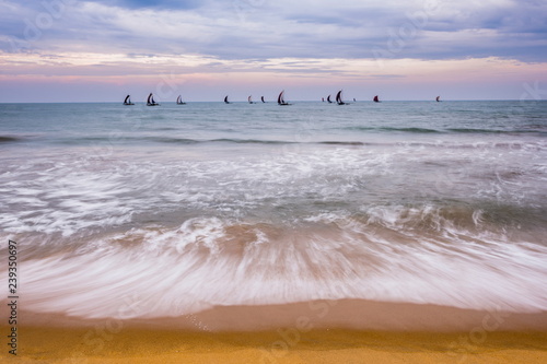 Negombo, traditional outrigger fishing boats (oruva) returning at sunrise to Negombo fishing market, Sri Lanka, Asia photo