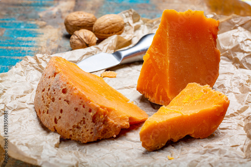Pieces of native French aged cheese Mimolette, produced in Lille with greyish curst made by special cheese mites