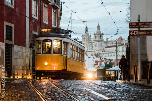 Romantic atmosphere in the old streets of  Alfama with the castle in the background and tram number 28 Lisbon Portugal Europe photo