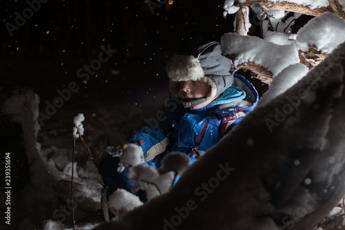 Little boy in a winter Christmas fairytale at night. A child near the luminous trees. © Konstiantyn Zapylaie