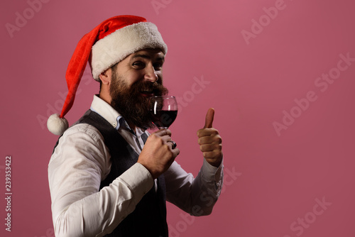 Bearded man tasting glass of wine. Degustation concept. New year party. Сheerful man holds wine&shows thumb up. Approval concept. Sommelier tasting red wine. Man in waistcoat drink glass of red wine.