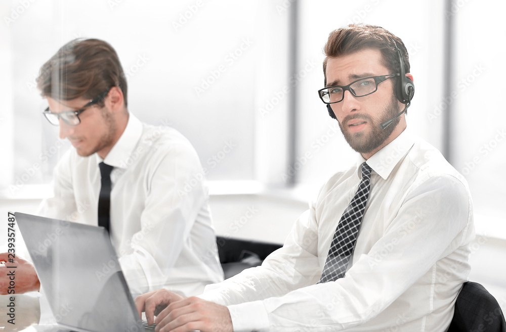 Tech support manager in headset consulting a client Tech support manager in headset consulting a client
