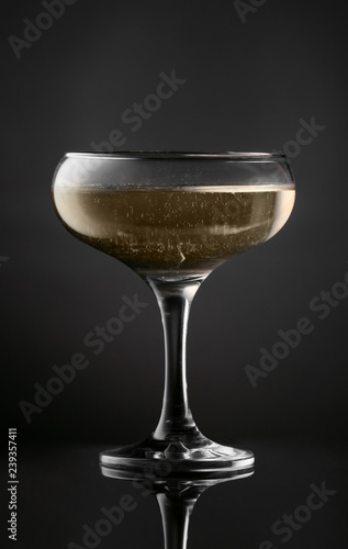 Glass of tasty champagne on dark background