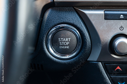 Button start and turn off the ignition of the car engine close-up on the dashboard, electric key, pressing drives the motor vehicle of modern design. © Aleksandr Kondratov