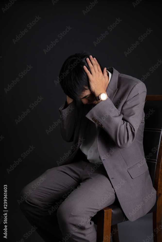 Emotion of depressed businessman having something in mind to worry on head. failure of business concept isolated on dark background. Emotion of depressed businessman having something in mind to worry on head. failure of business concept isolated on dark background.