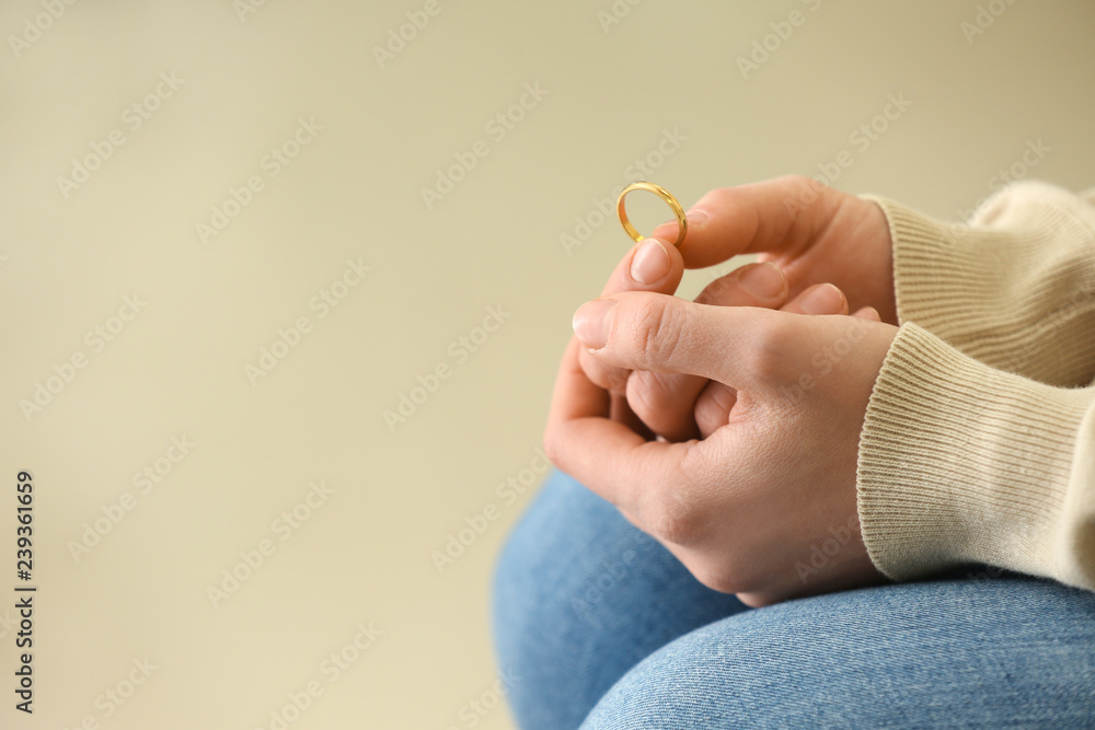 Woman holding ring, closeup. Concept of divorce - obrazy, fototapety, plakaty 