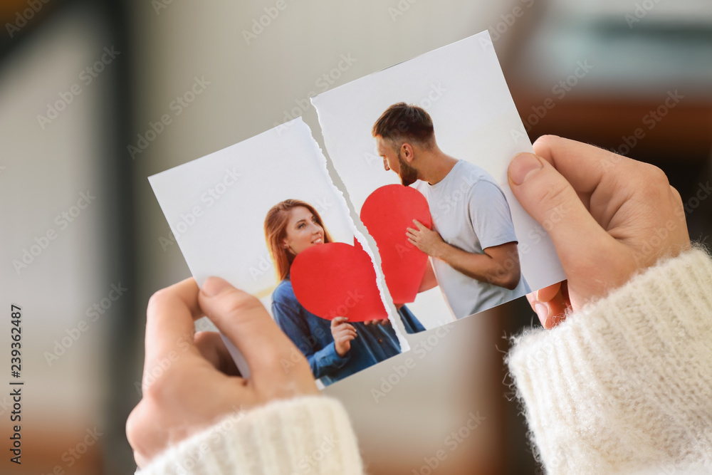 Woman tearing up photo of happy couple, closeup. Concept of divorce - obrazy, fototapety, plakaty 