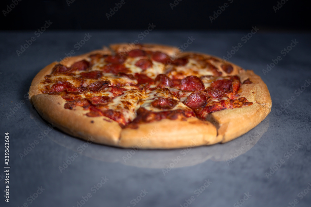 Fresh pepperoni pizza on grey Fresh pepperoni pizza on grey