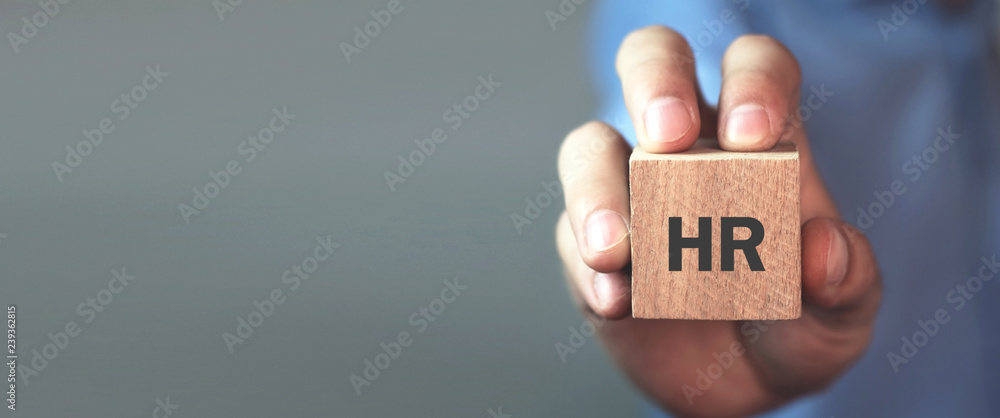 Man holding HR word on wooden cube. - obrazy, fototapety, plakaty 