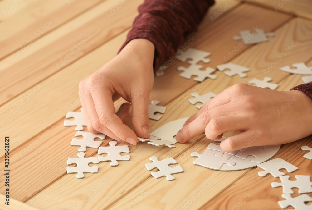 Obraz premium Woman assembling puzzle on table