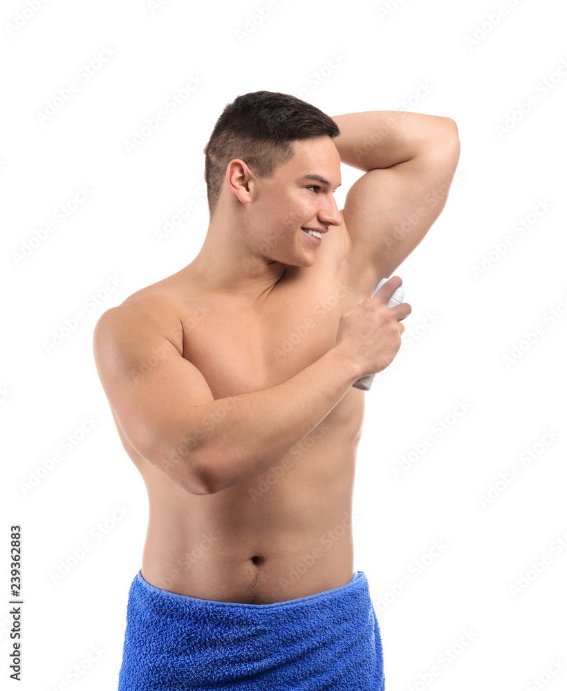 Fototapeta premium Young man using deodorant on white background
