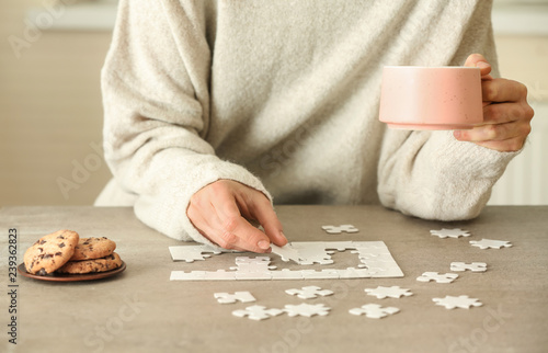 Woman assembling puzzle on table