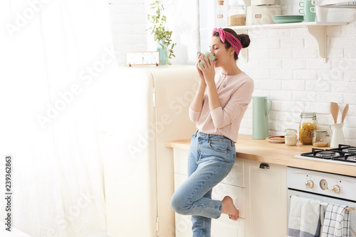 Portrait of beautiful young woman having breakfast in the kitchen
