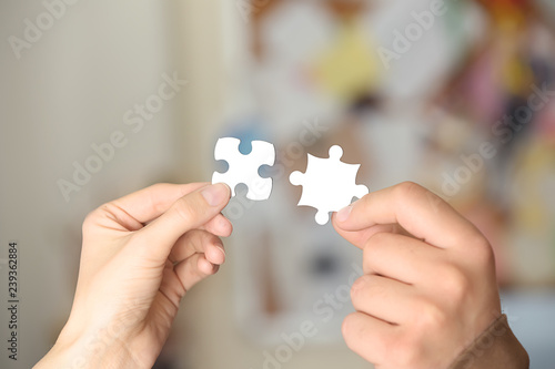 Male and female hands with pieces of puzzle, closeup