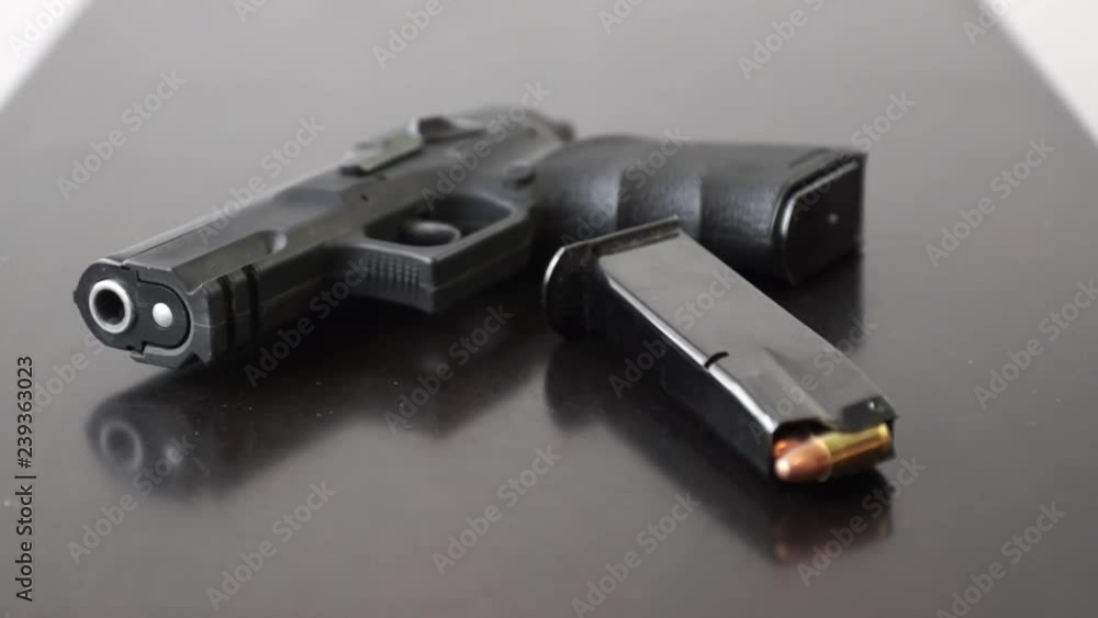 9mm Gun and Magazine on table Tilt shot of 9mm Gun and Magazine on table 9mm Gun and Magazine on table Tilt shot of 9mm Gun and Magazine on table