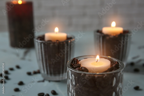 Burning candles in holders on table
