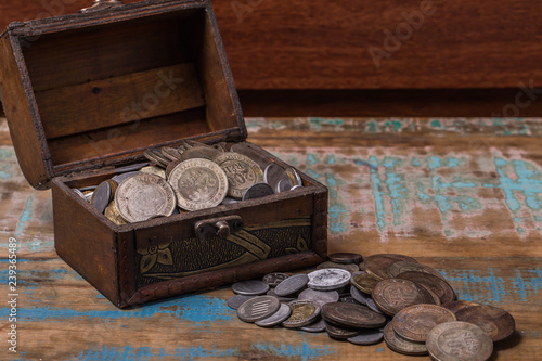Chest of old Brazilian coins on a wooden demolition background