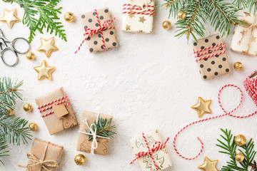 Christmas gift boxes, decorations, bakers twine & spruce on white background. Wrapped gifts, Cristmas preparation. Copy space.