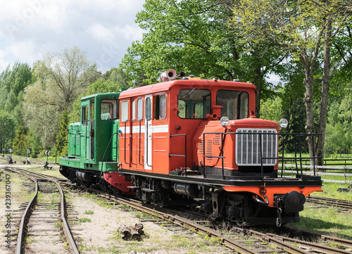 Old train and locomotive. Railroad tracks stretches and green grass and trees. Railway road environment background.