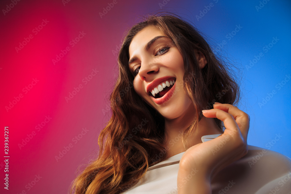 Happy woman standing, smiling on colored studio background. Beautiful female half-length portrait. Young satisfy woman. Human emotions, facial expression concept. Happy woman standing, smiling on colored studio background. Beautiful female half-length portrait. Young satisfy woman. Human emotions, facial expression concept.