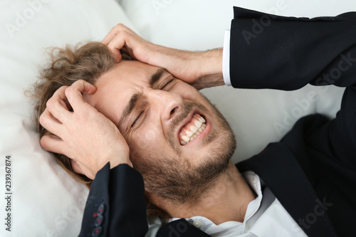 Young businessman suffering...