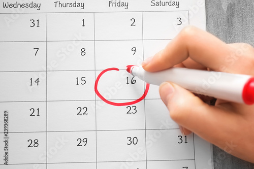 Fotografija Female hand encircling date in calendar, closeup