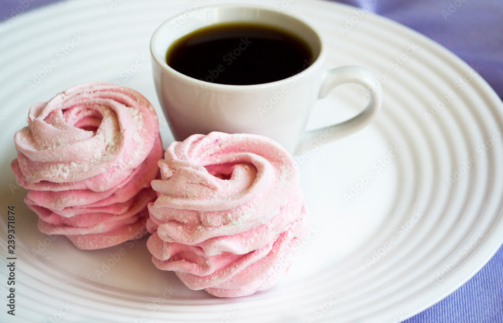 Homemade pink zephyr or marshmallow in white plate with cup of coffee. Homemade pink zephyr or marshmallow in white plate with cup of coffee.