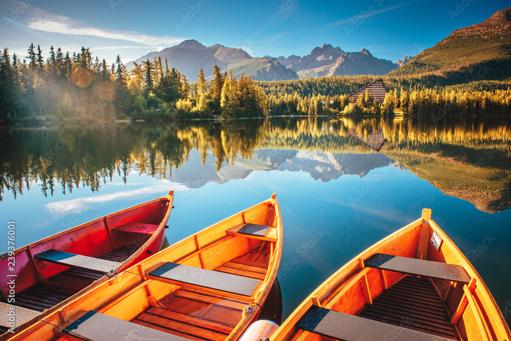 Morning lake Strbske pleso in Tatra mountains. Colorful boats on the water