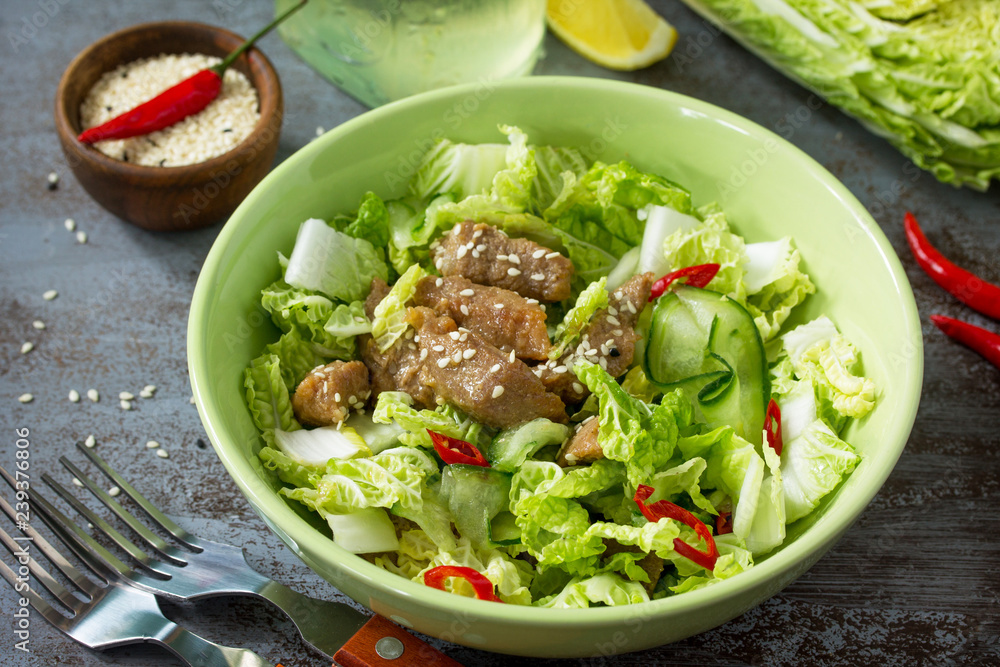 Diet menu, Vegan food. Healthy salad with Chinese cabbage, chicken, sesame and chili pepper on a dark stone table. Diet menu, Vegan food. Healthy salad with Chinese cabbage, chicken, sesame and chili pepper on a dark stone table.