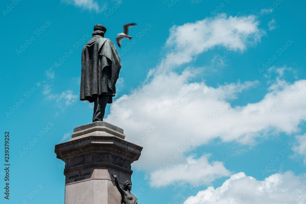 Statue on saturated sky and flying seagull