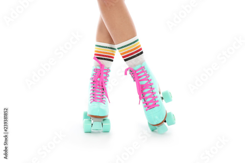Young woman with vintage roller skates on white background, closeup view