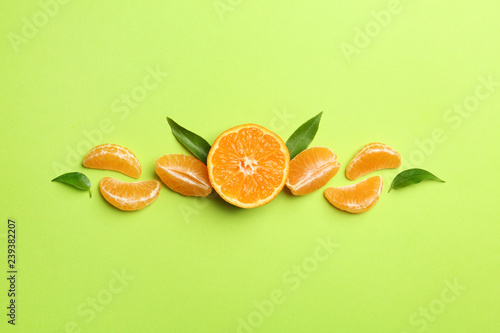 Fototapeta Naklejka Na Ścianę i Meble -  Composition with tangerines and leaves on color background, flat lay