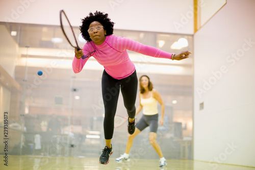 Two women playing racquetball together. photo