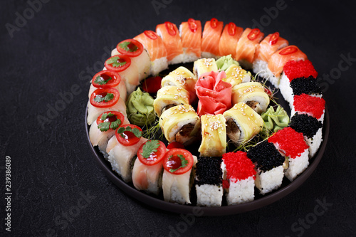 sushi, japanese food, deluxe restaurant menu, delicious traditional seafood. maki rolls set with salmon and caviar, served on black plate, close up