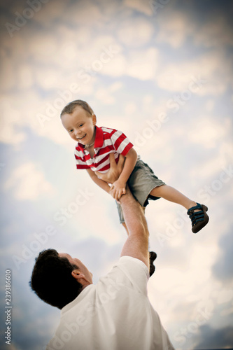 Smiling young boy being held aloft by his father. photo