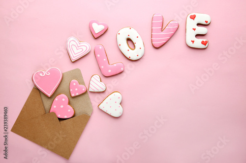 Inscription Love by homemade cookies with envelope on pink background