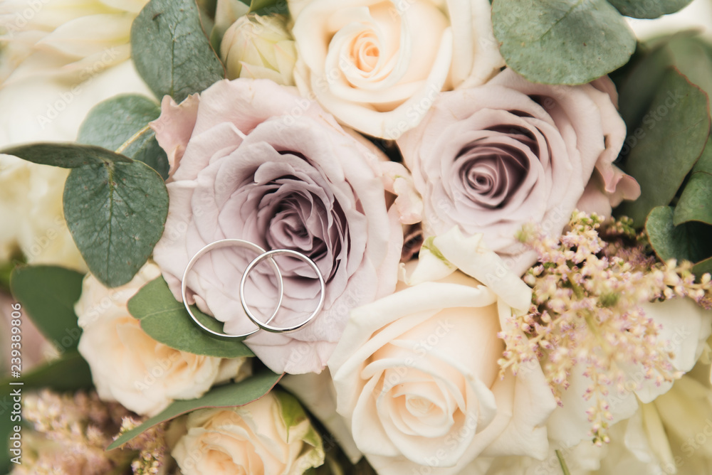 Beautiful wedding rings on the background of the bride's bouquet in pastel colors Beautiful wedding rings on the background of the bride's bouquet in pastel colors