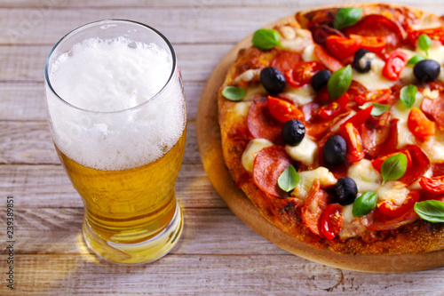 Glass of beer and pizza on wooden table. Beer and food concept. Ale.