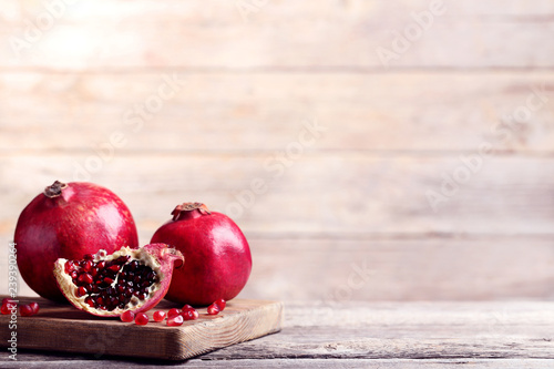 Ripe and juicy pomegranate on wooden cutting board